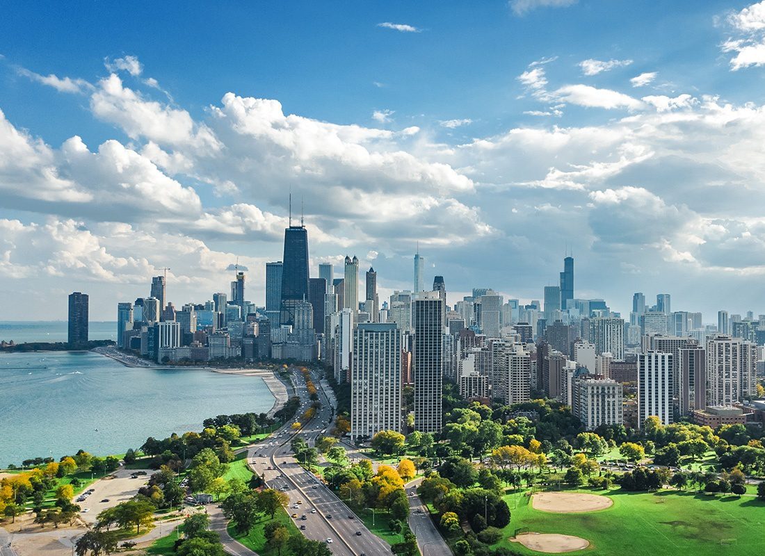 Contact - Aerial View of Chicago With Tall Buildings by the Lake on a Partly Sunny and Cloudy Day